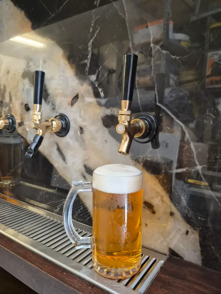 Cold beer pour from the brass tap